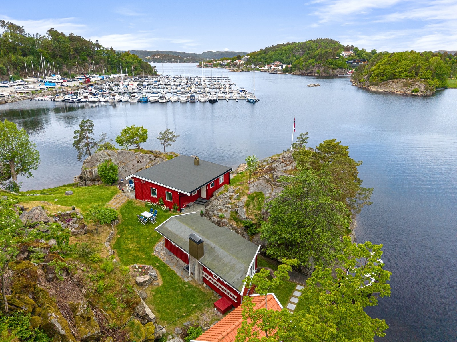 Dronebilde over eiendommen med Hånesbukta og småbåthavna utenfor Galleribilde
