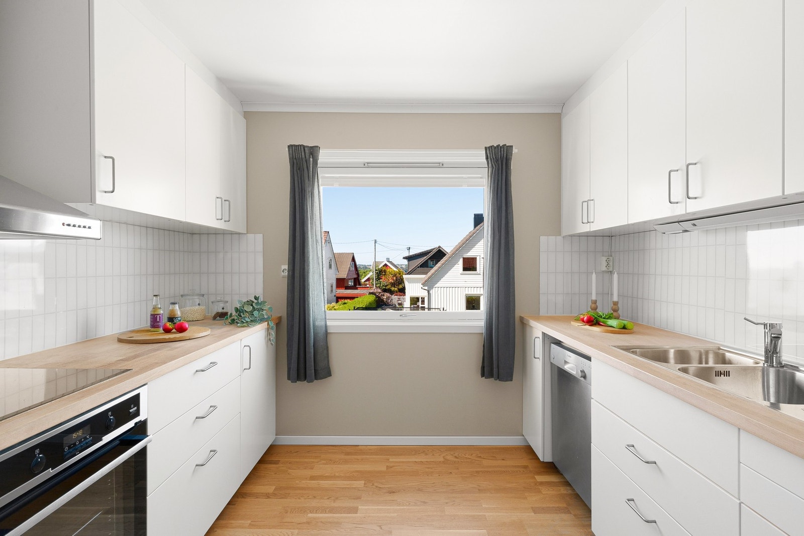 Kjøkkenet ligger i eget rom i 2. etasje og har en lys innredning med slette fronter, benkeplate i tre og hvite fliser over benkesonen. Galleribilde
