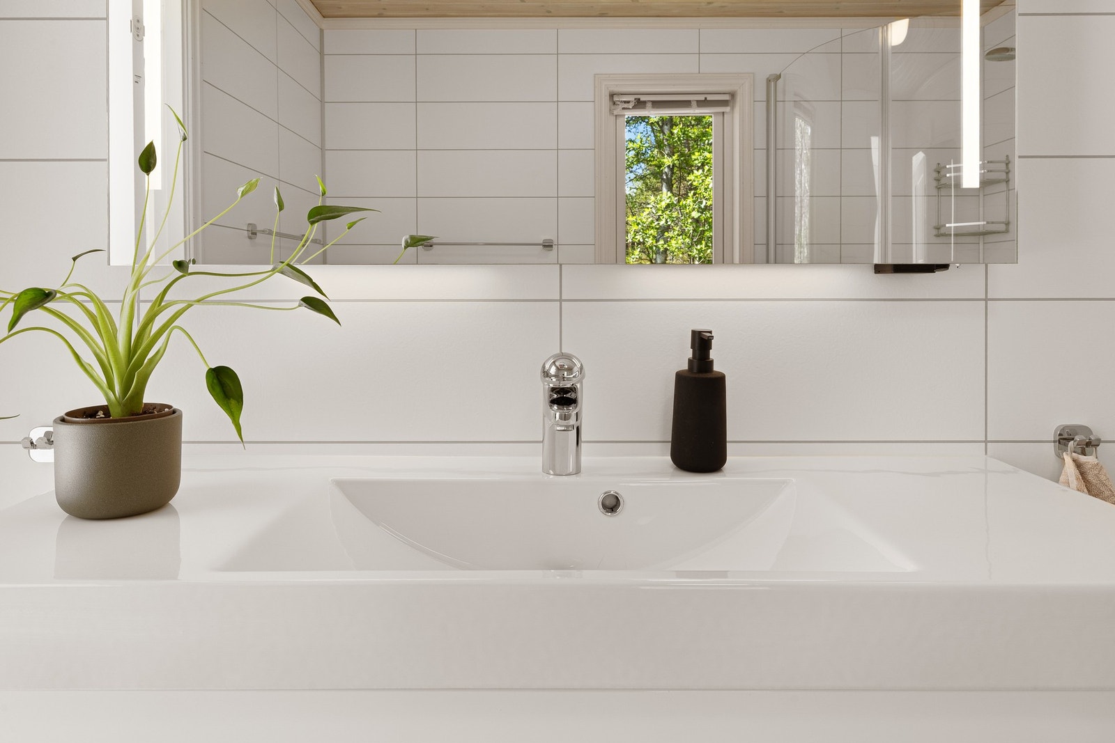 Badet har en praktisk dusjnisje og er utstyrt med baderomsvifte på vegg. Galleribilde