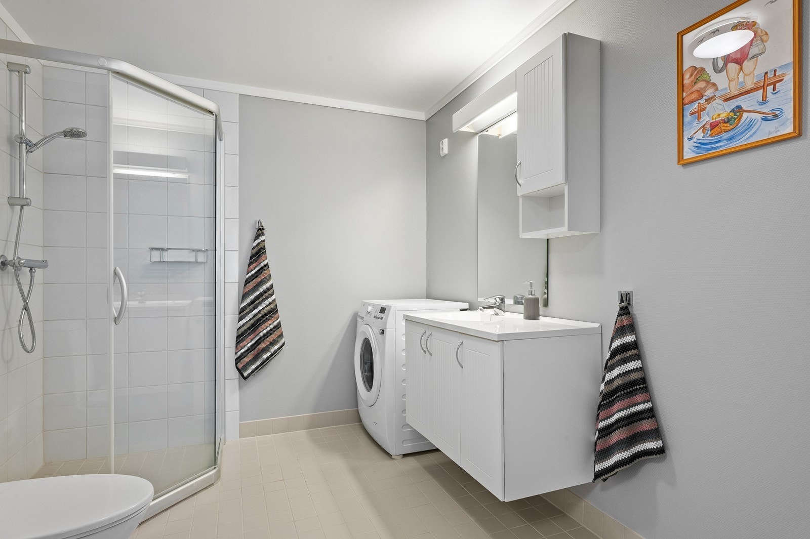 Badet er innredet med dusjhjørne, toalett, servant og har opplegg for vaskemaskin. Galleribilde
