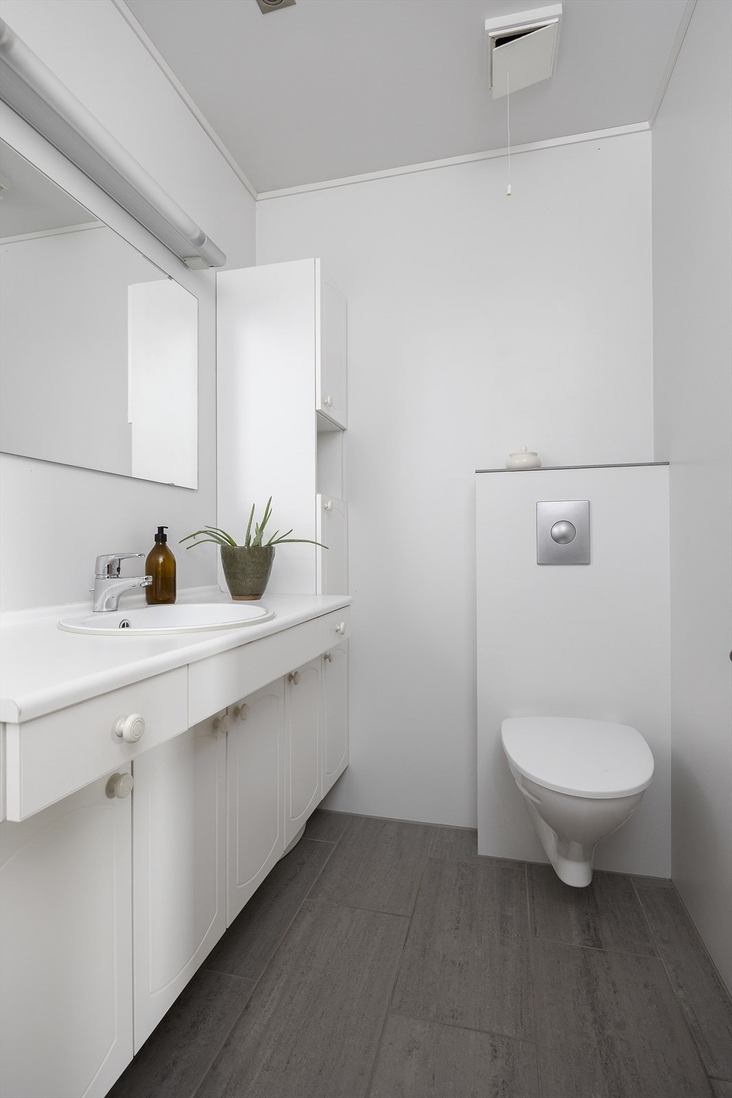 Badet har flislagt gulv og våtromstapet på veggene. Galleribilde