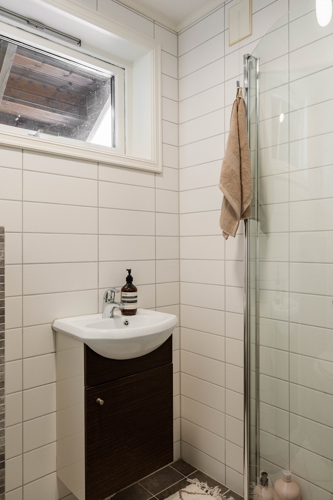 Badet er utstyrt med dusjhjørne med svingbare glassdører. Galleribilde