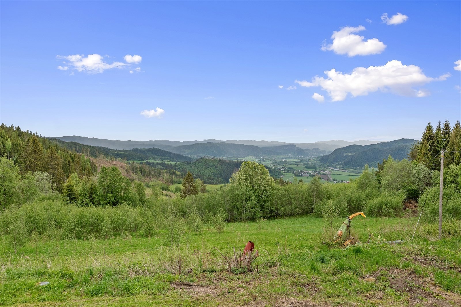 Plasseringen gir eventyrlig panoramautsikt over grønne enger, skogkledde åser og høye fjelltopper i det fjerne. Galleribilde