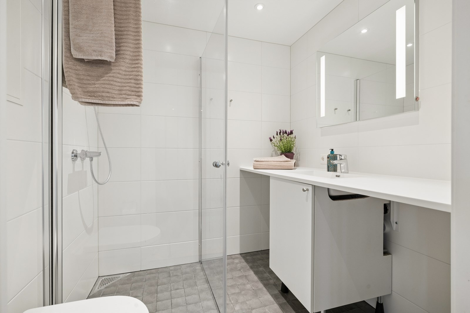 Badet i tilknytting til gangen er på 3,4 kvm, med downlights i taket. Galleribilde