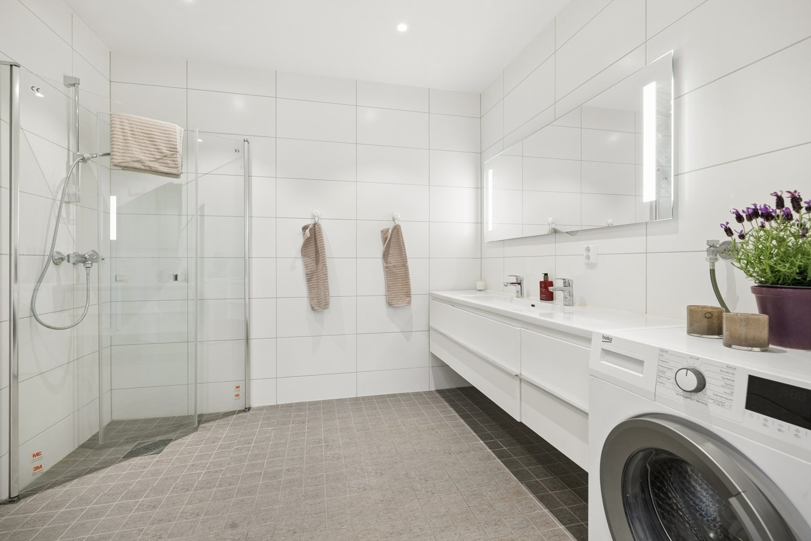 Delikat bad med dusj, opplegg for vaskemaskin og moderne innredning. Stort dusjhjørne. Galleribilde