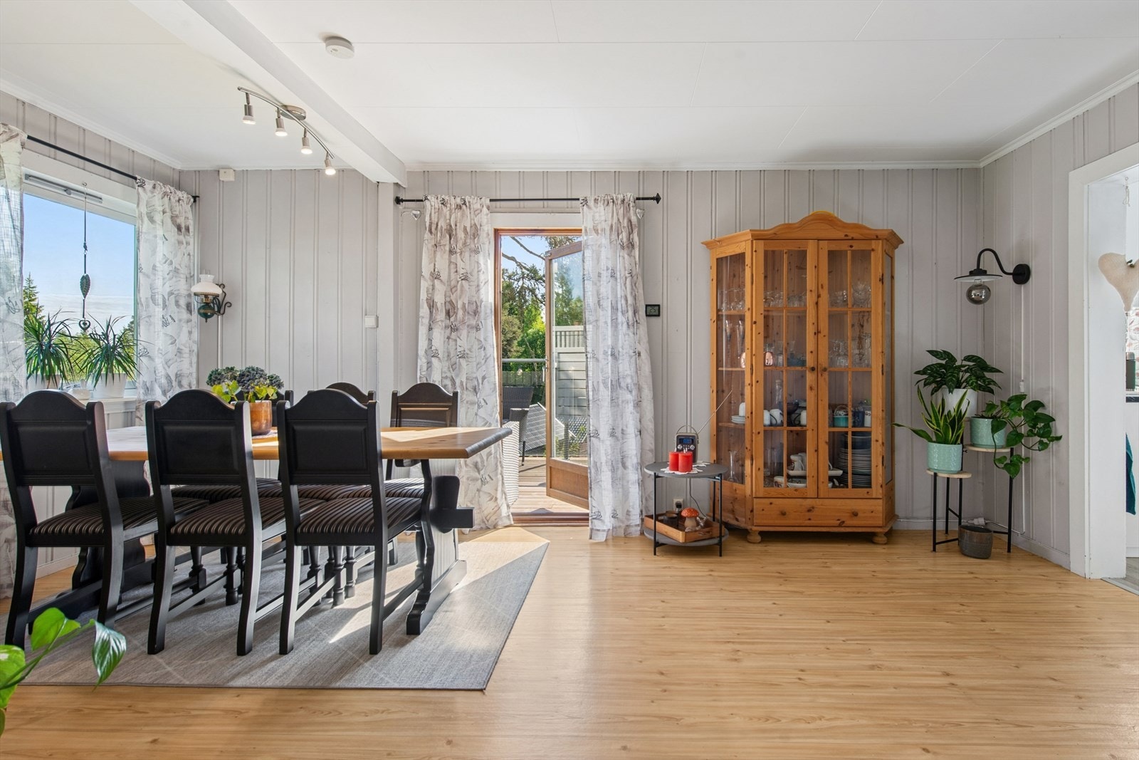 Romslig og luftig oppholdsrom med god plass til langbord, hvor lyset strømmer inn og skaper en behagelig atmosfære. Galleribilde