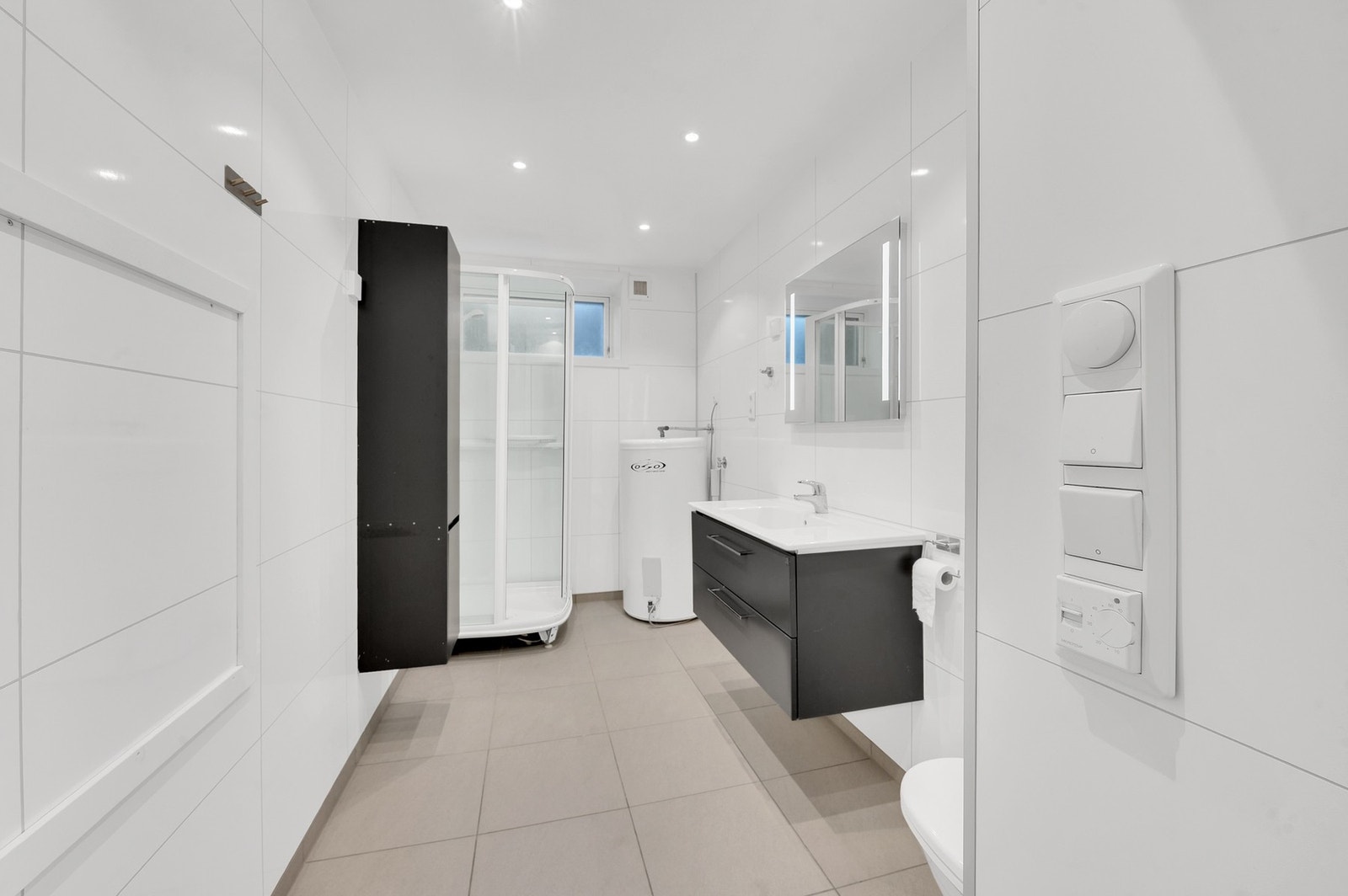 Badet er lyst og funksjonelt med dusjkabinett og moderne innredning. Det er dimbare spotter i tak og varme i gulv. Galleribilde
