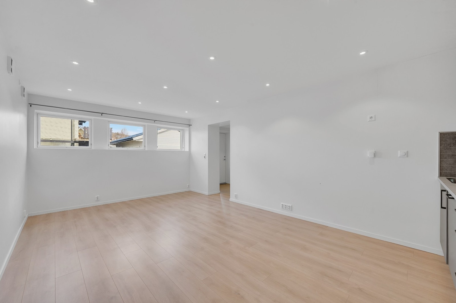 Oppholdsrommet har downlights i taket og et lyst, moderne gulv. Galleribilde
