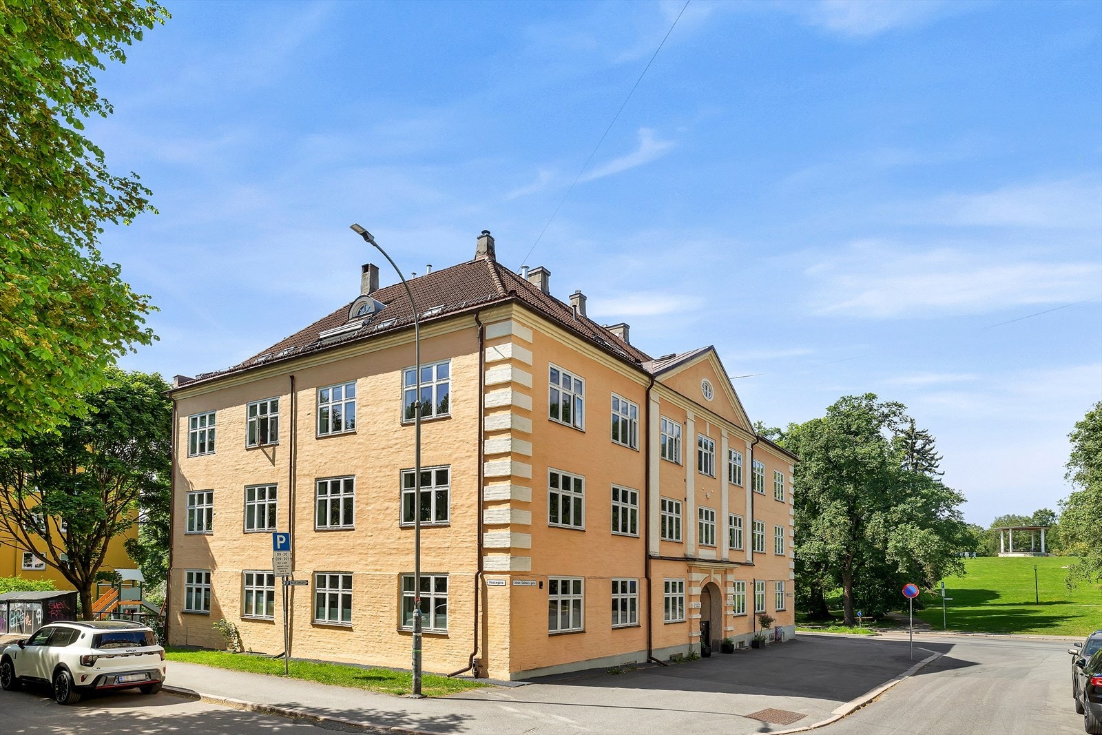 Flott, klassisk fasade omgitt av grønne omgivelser. Galleribilde
