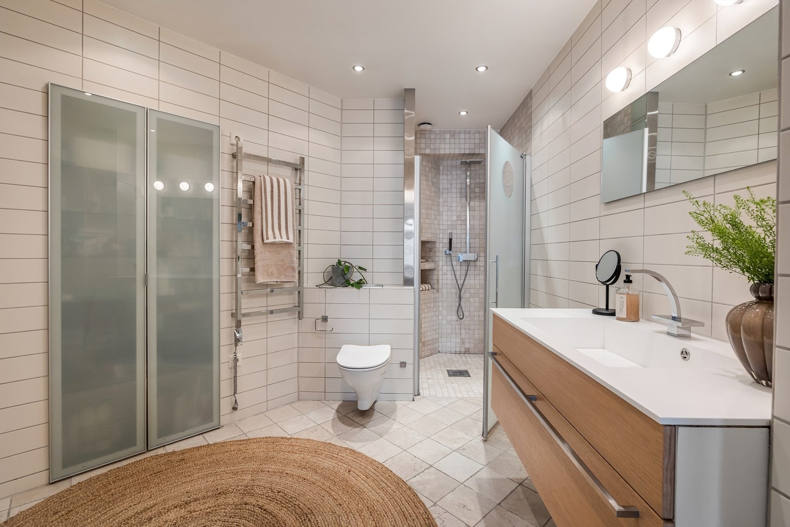 Badet har flislagte overflater og inneholder en dusjnisje med innfelt oppbevaring. Galleribilde