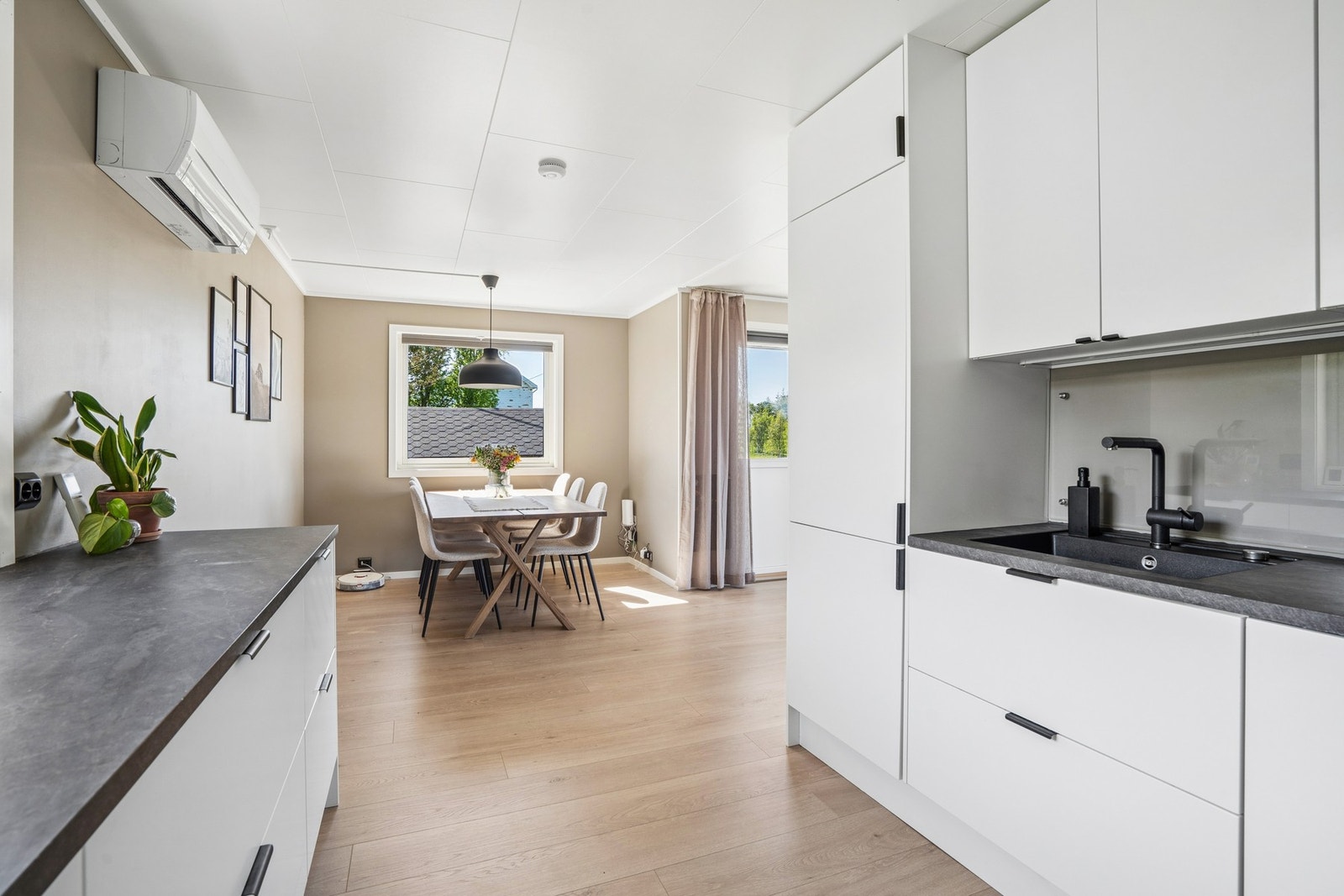 Kjøkkeninnredningen fra 2022 har slette fronter og en slitesterk laminatbenkeplate. Galleribilde