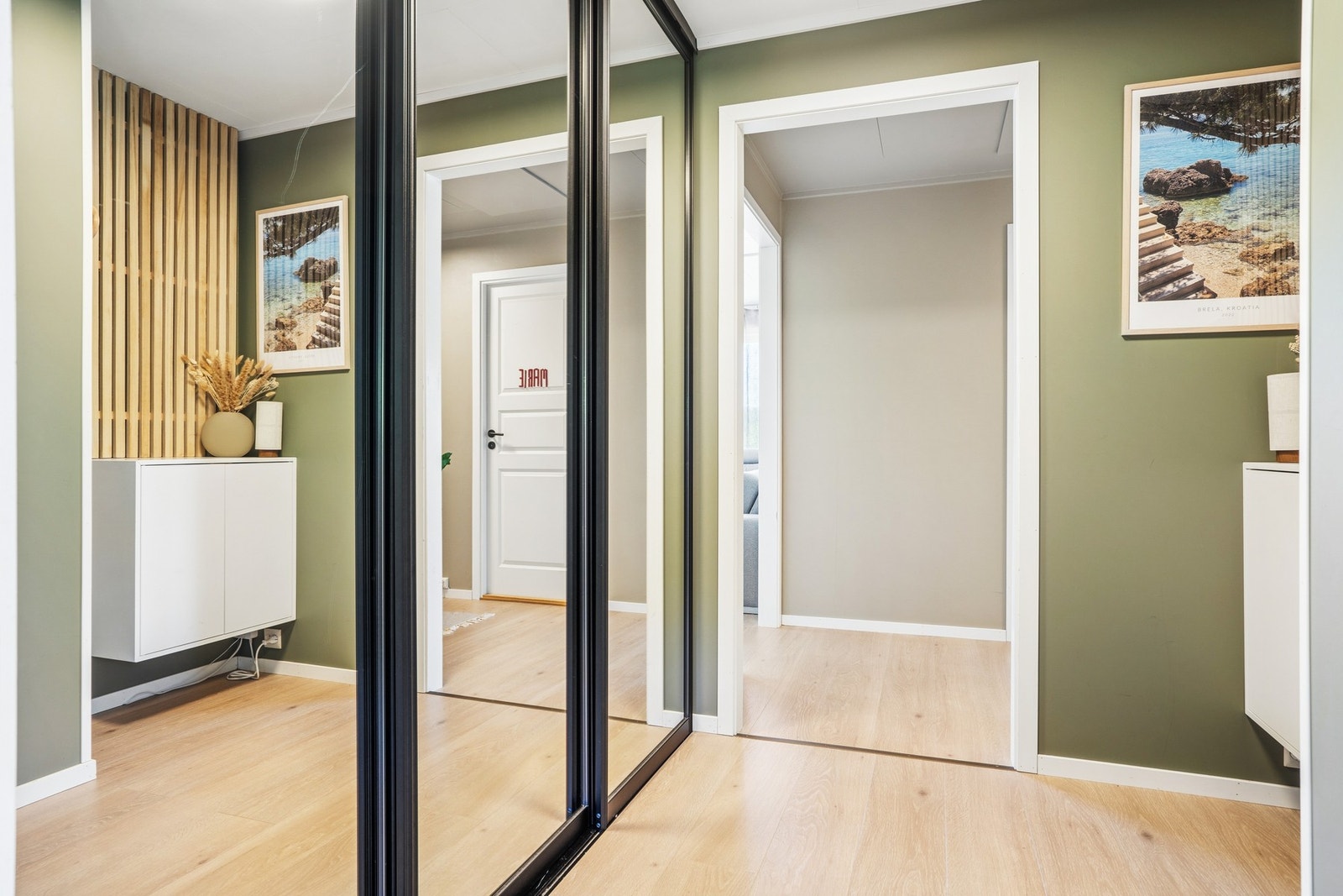 Entréen har en praktisk garderobeløsning med skyvedører og speilfronter. Galleribilde