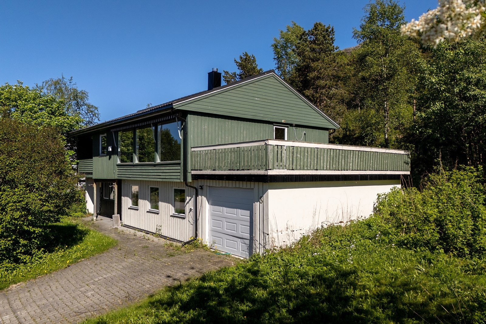 Boligen ligger i skrånende terreng med adkomst fra opparbeidet gårdsplass. Galleribilde