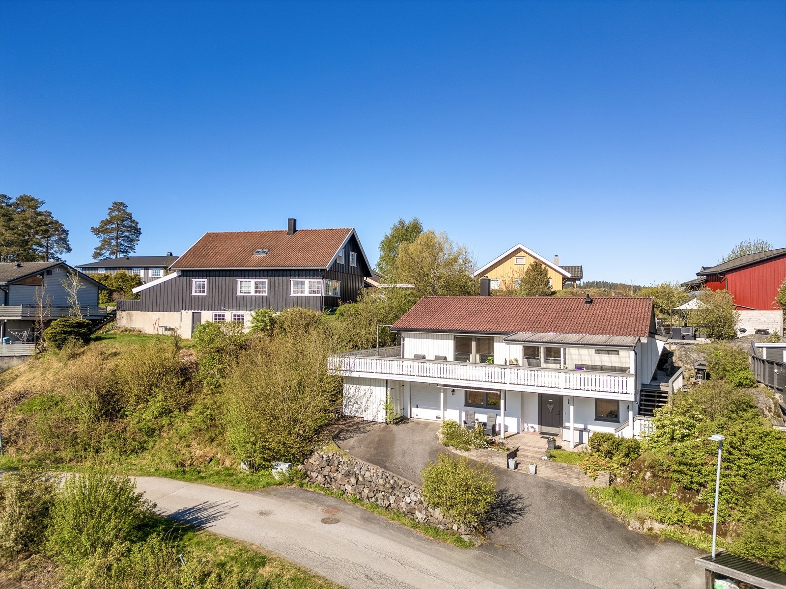 Boligen ligger fint plassert i terrenget og byr på en romslig terrasse som strekker seg langs hele fasaden, med gode solforhold og hyggelig utsyn mot nærområdet. En bolig som kombinerer familievennlig planløsning med en lun og hjemmekoselig atmosfære. Galleribilde