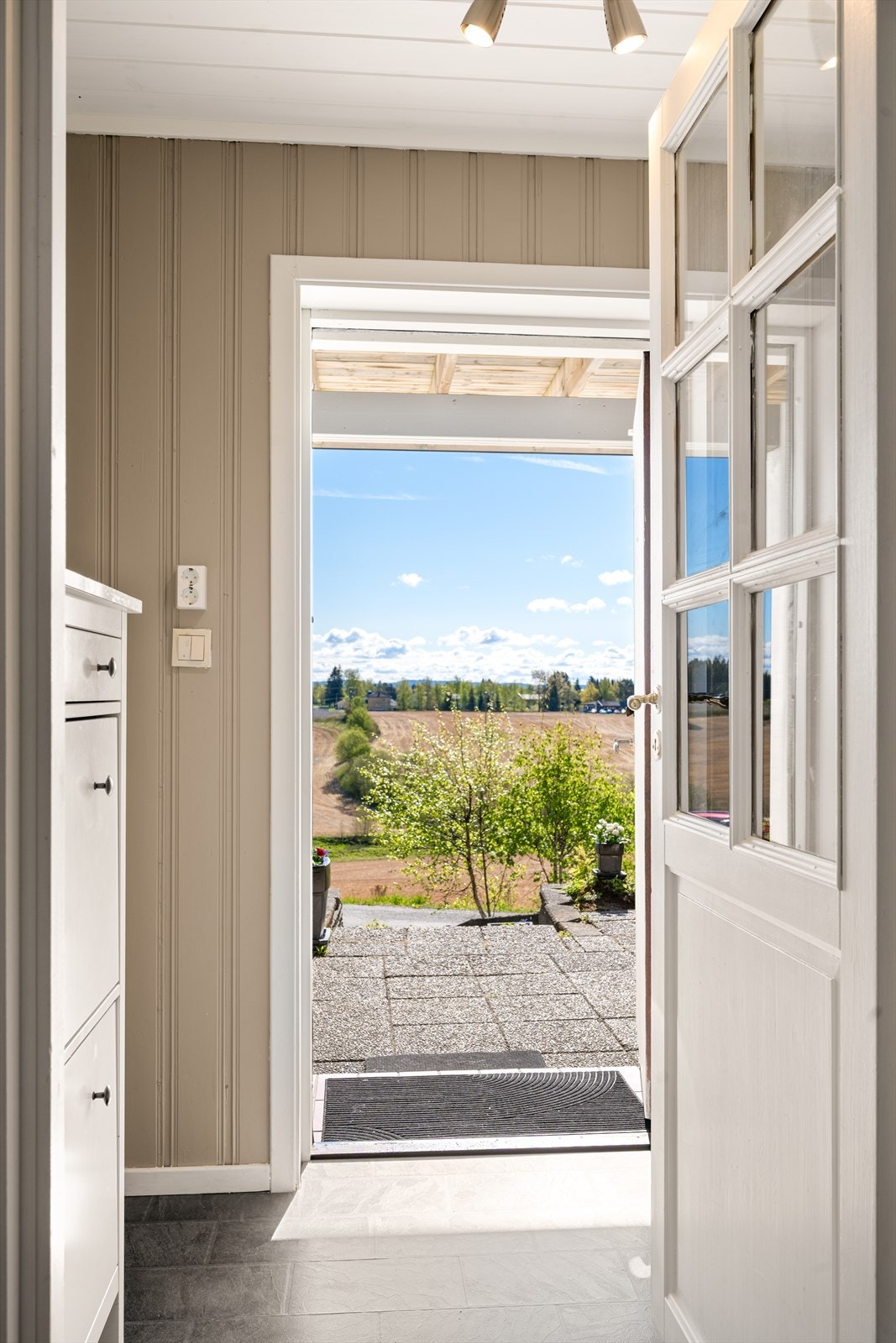 Velkommen inn! Døren med glassfelt inn mot mellomgangen slipper lyset videre inn i boligen og skaper en luftig og innbydende entré. Galleribilde