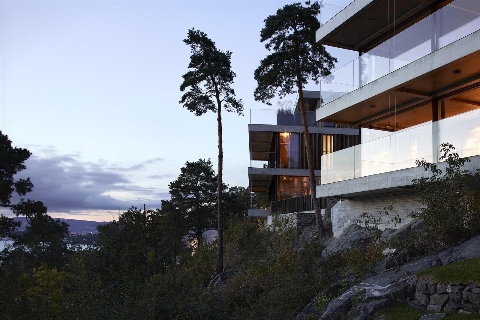 Boligen ligger i skrånende terreng med utsyn mot sjøen og en arkitektur tilpasset naturtomten Galleribilde