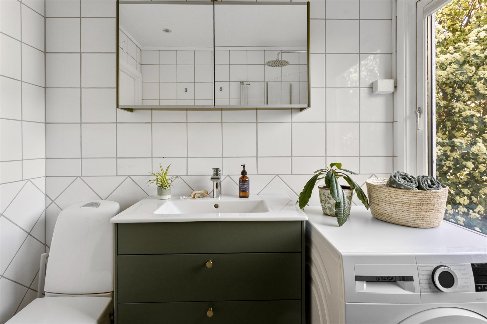 Badet er innredet med servant med underskap, speilskap, toalett og dusjhjørne med glassvegger. Galleribilde