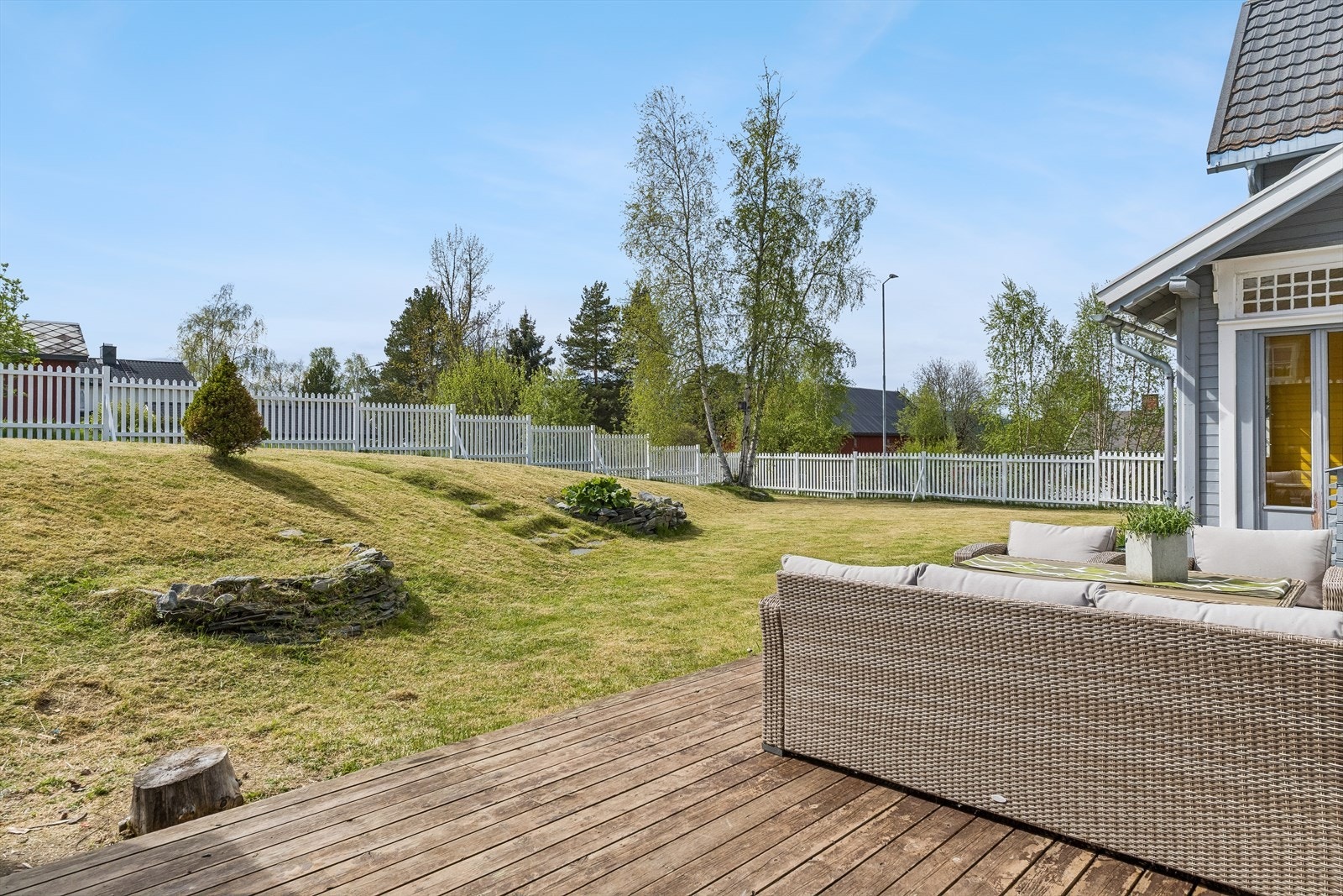 Terrasse bygget på terreng med god plass til utemøbler. Romslig og fint opparbeid hage. Galleribilde
