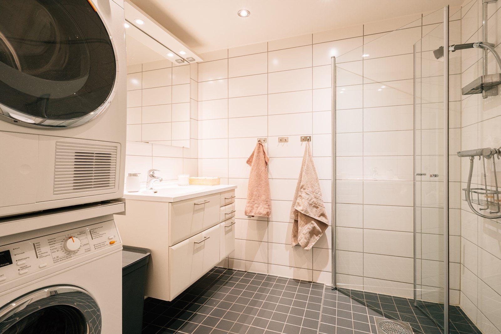 Stilrent hovedbaderom med mørke fliser på gulv og lyse fliser på vegger som gir en fin kontrast. Galleribilde