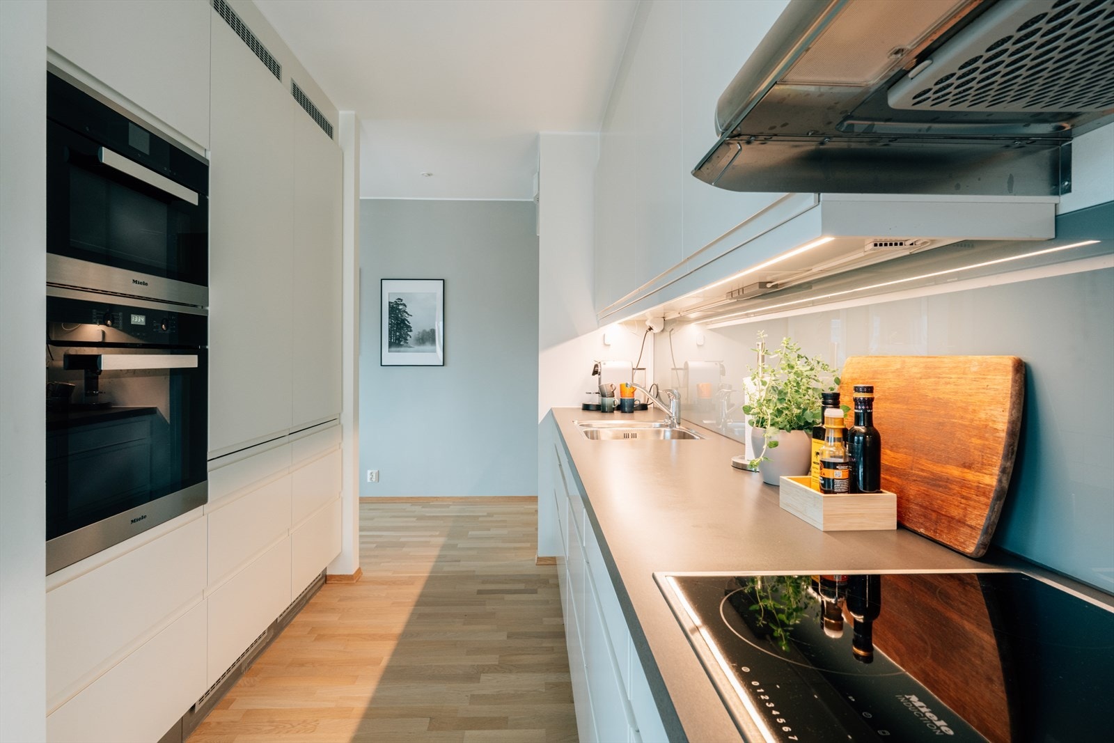 Moderne HTH-kjøkken med stilrene, glatte hvite fronter som gir et tidløst uttrykk. Galleribilde