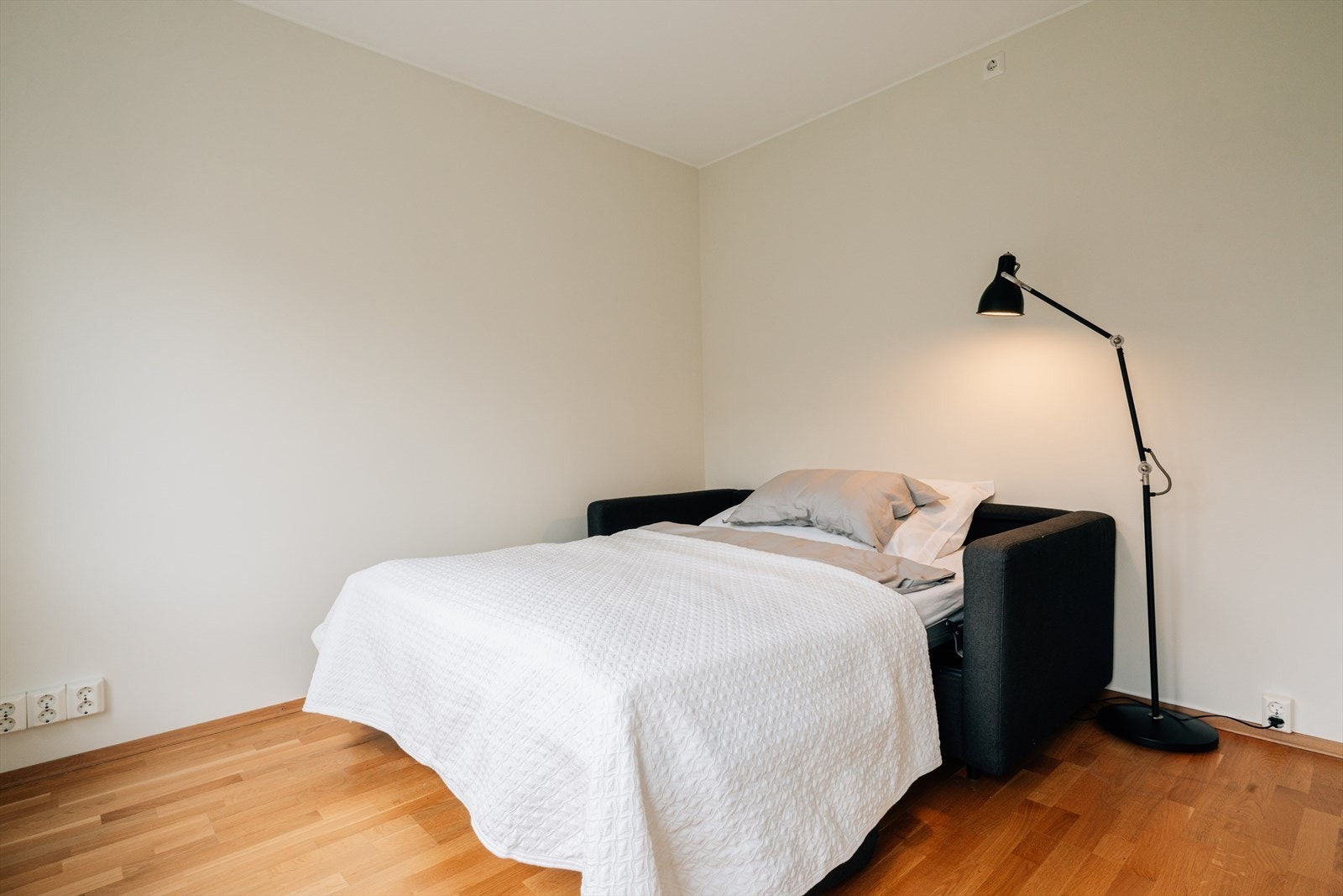Rommet har plass til både sofa og seng, samt garderobeskap for praktisk oppbevaring. Galleribilde