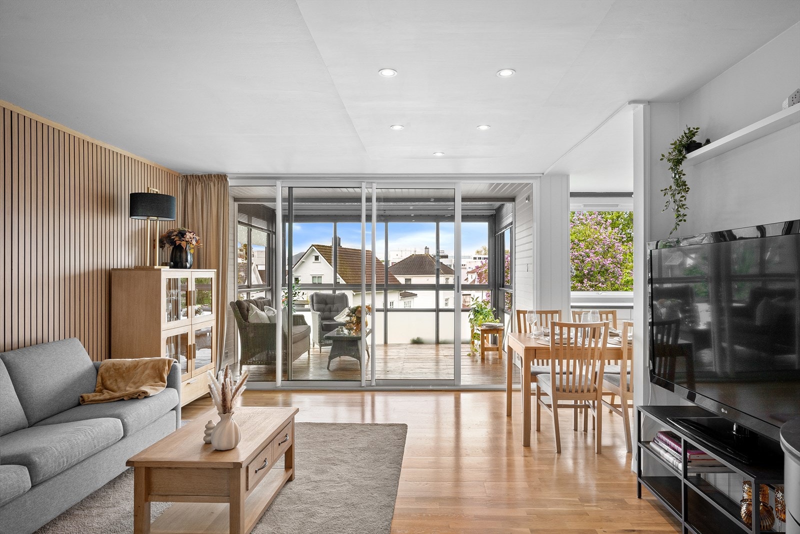Stuen har plass til både sofagruppe og spisebord, og en skyvedør åpner opp mot den innglassede balkongen. Galleribilde
