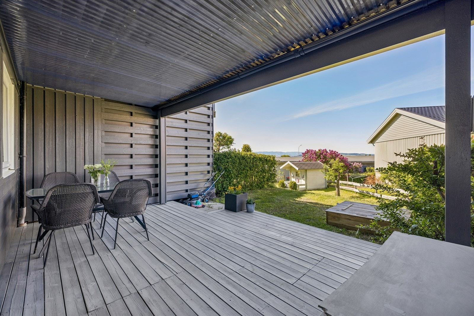 Stor overbygd terrasse i sokkeletasjen med god plass til sittegruppe. Galleribilde