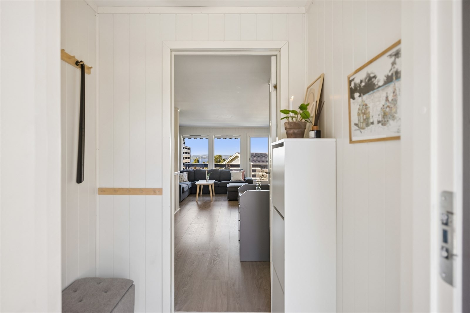 Velkommen inn! Vindfanget leder inn til en lys og åpen stue med gjennomgående laminatgulv. Galleribilde