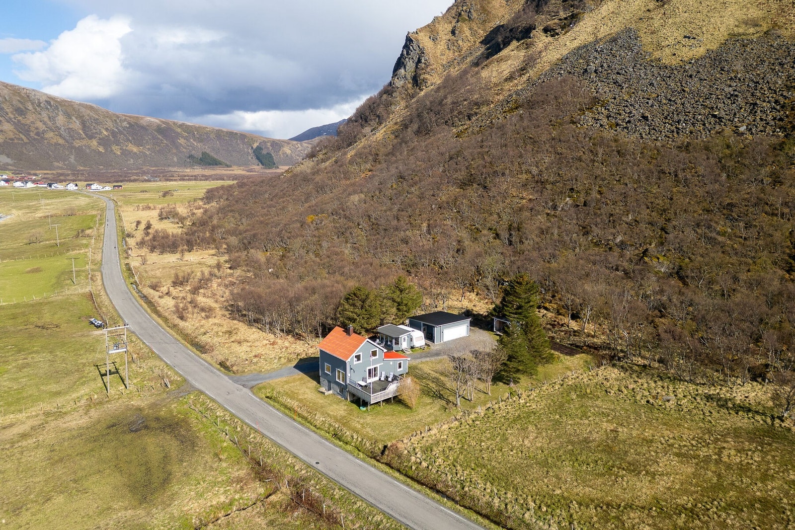 Eiendommen ligger i lett skrånende terreng, omkranset av fjell og åpent landskap. Galleribilde