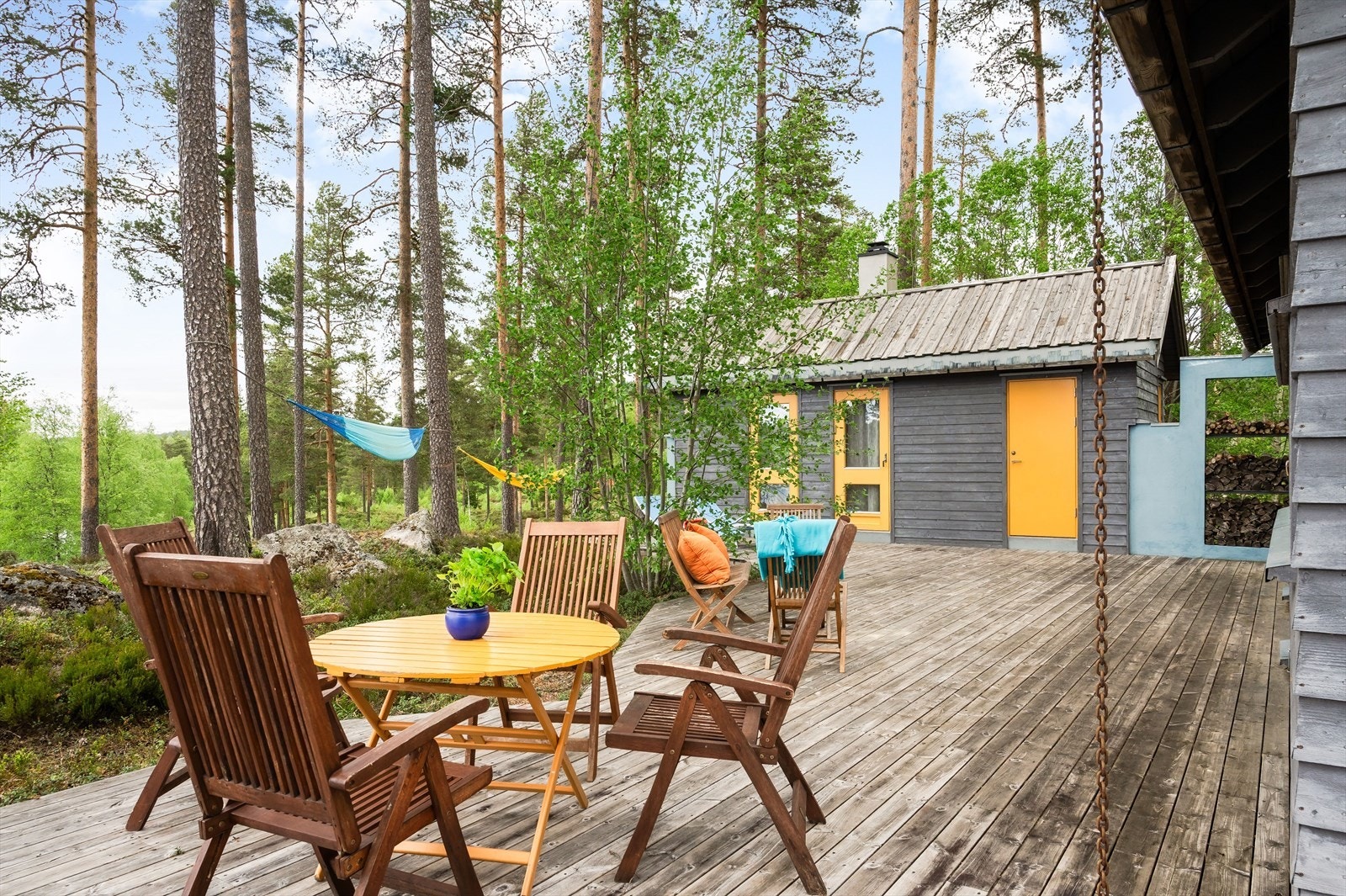 Terrassen er fint bygget inn i terrenget og omringet av de to byggene, trær og naturtomt. Trærne fungerer fint til f.eks. hengekøye. Galleribilde
