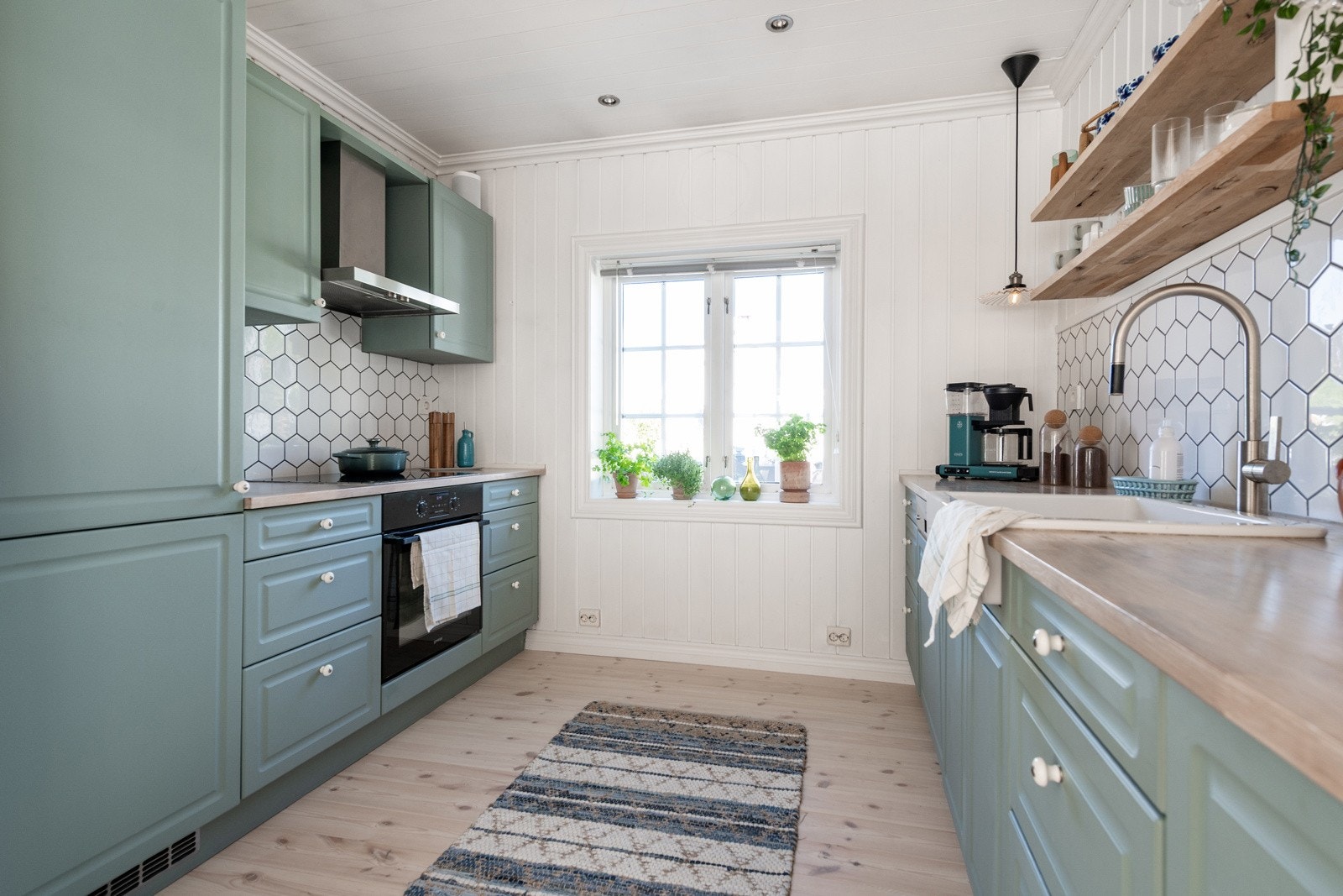 Kjøkkeninnredningen står i stil med resten av huset og består av fronter i malt MDF, skrog i foliert spon og benkeplate i heltre. Galleribilde