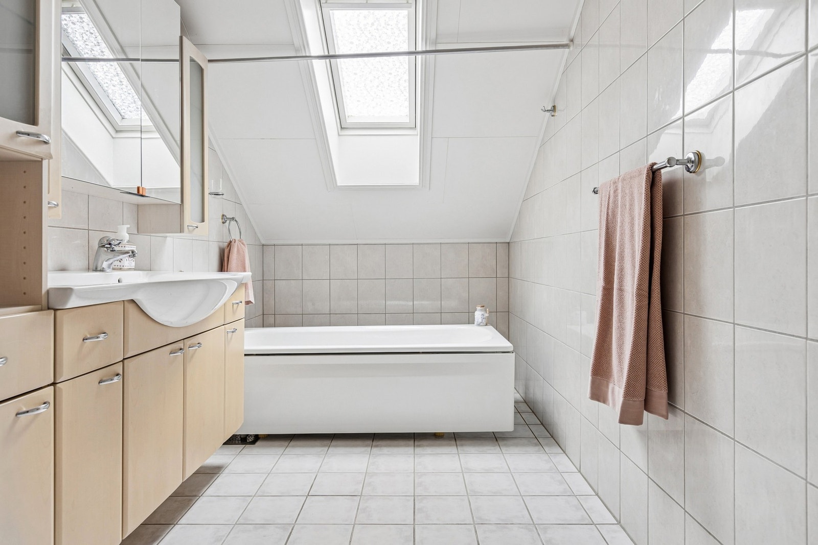 Badet i første etasje har flislagt gulv med elektriske varmekabler og badekar Galleribilde