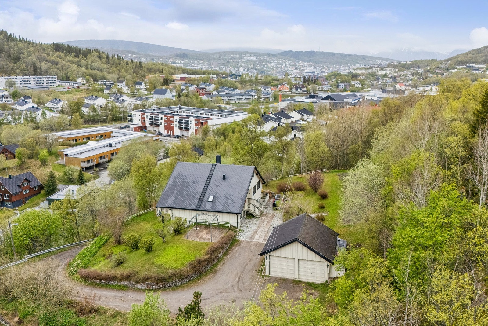 Oversikt over eiendommen, som inkluderer enebolig og en romslig dobbeltgarasje. Galleribilde