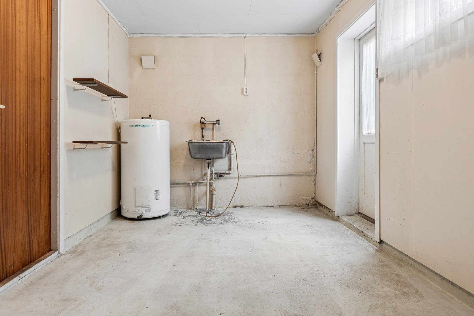 Praktisk vaskerom i underetasjen med malt betonggulv, utslagsvask og opplegg for vaskemaskin. Galleribilde