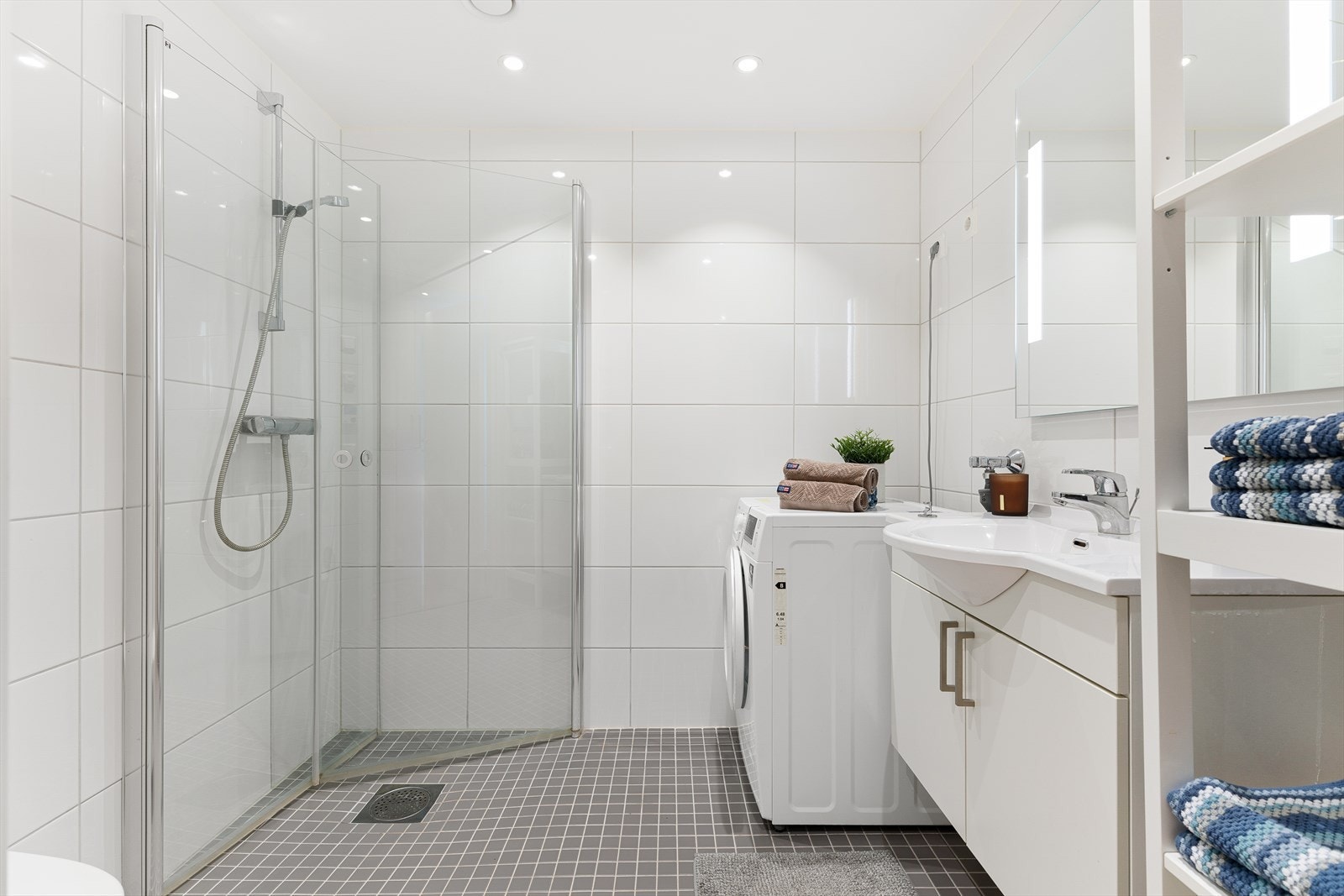 Det 4 m² store badet fremstår som innbydende med helflisede overflater, behagelig gulvvarme og downlights i tak. Galleribilde