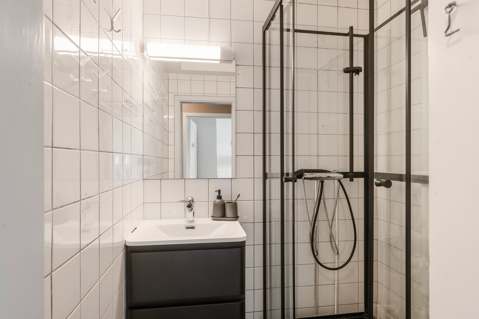 Delikat flislagt baderom med servant med underbygg og dusjkabinett. Galleribilde