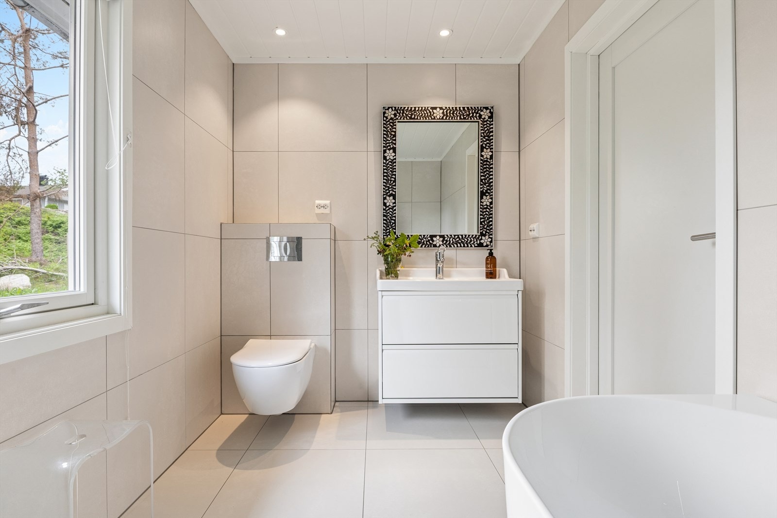 Ekslusivt og stilrent bad i andre etasje med flisbelagte gulv og vegger. Badet ligger i praktisk tilknytning til soverommene i hovedetasjen. Galleribilde