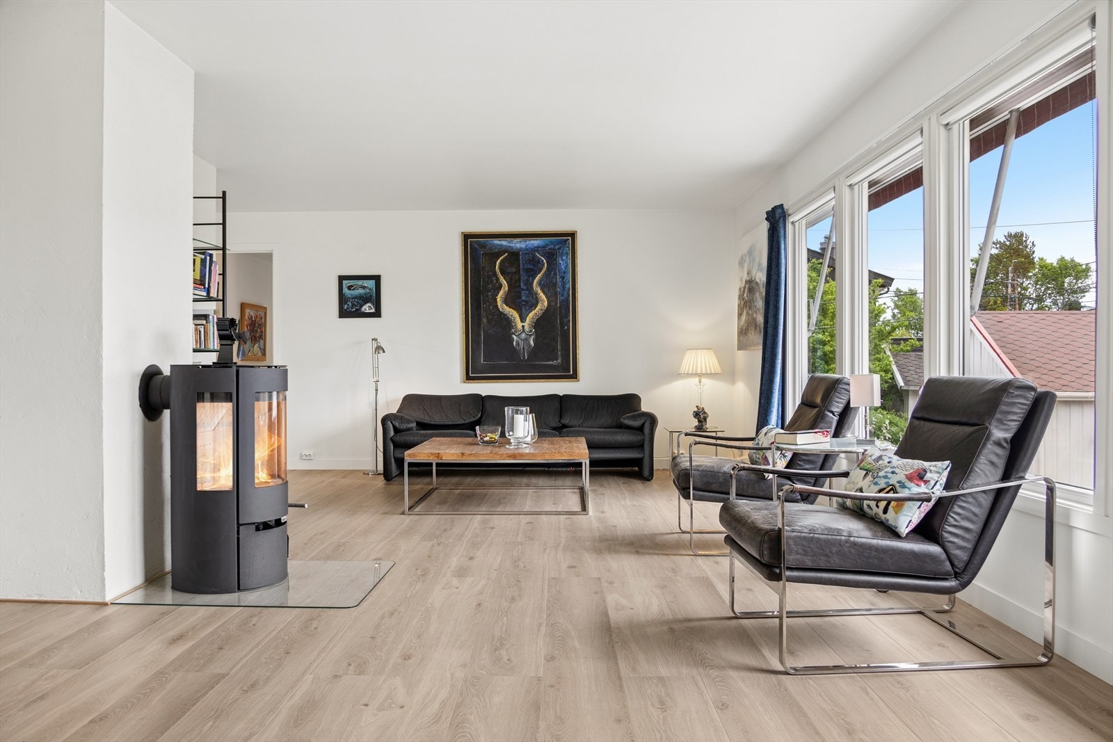 Stuen fremstår romslig og moderne, med godt lysinnslipp og en praktisk, moderne peis som bidrar til en lun atmosfære. Galleribilde