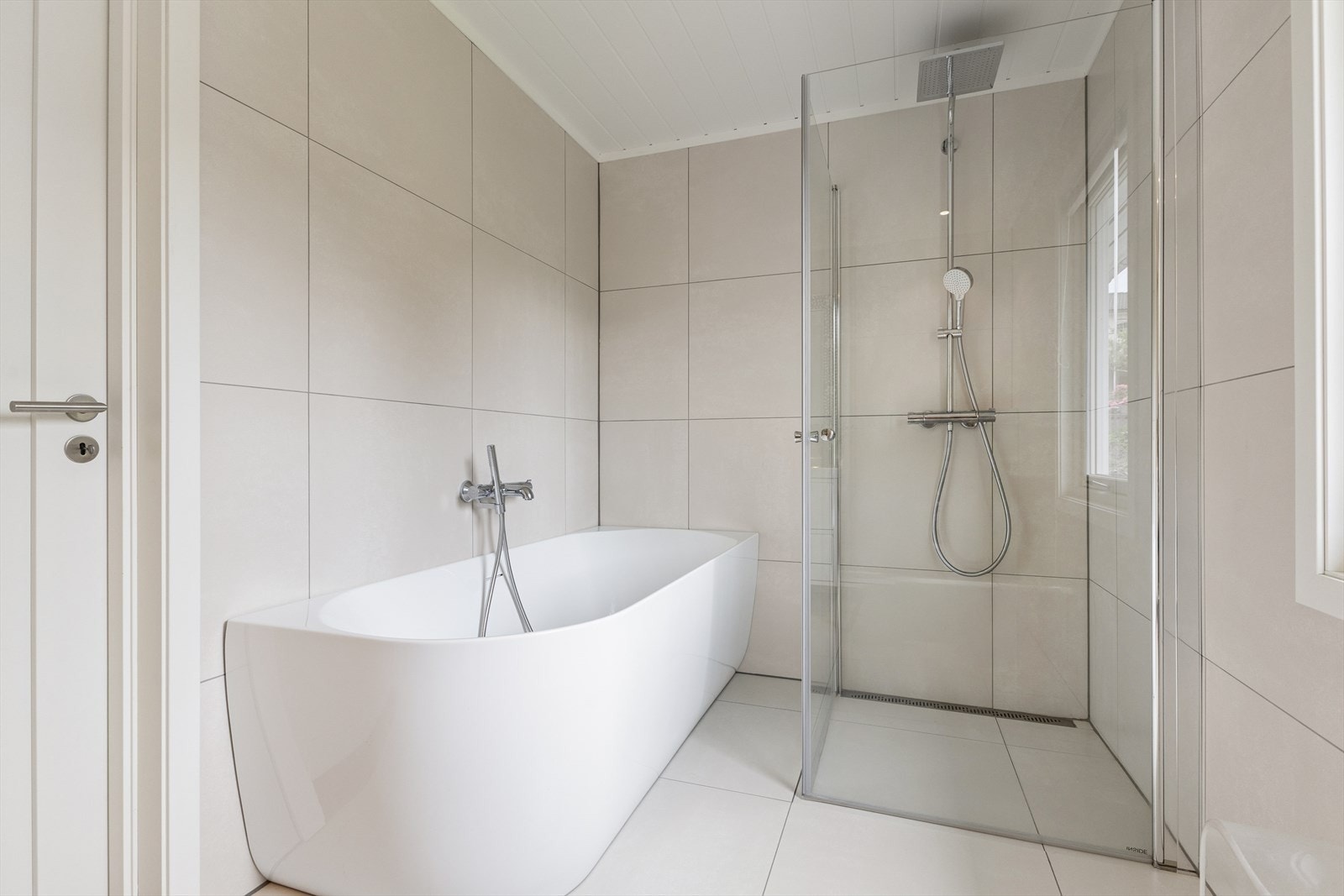 Ekslusivt og stilrent bad i andre etasje med flisbelagte gulv og vegger. Badet ligger i praktisk tilknytning til soverommene i hovedetasjen. Galleribilde