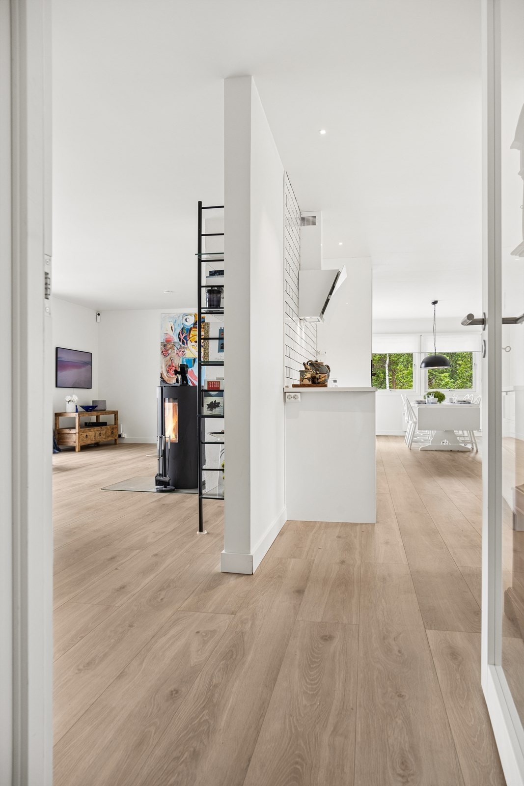 Skillevegg som på en praktisk måte avgrenser stuen fra kjøkkenet, samtidig som den legger til rette for et gjennomgående godt lys i begge rom. Galleribilde