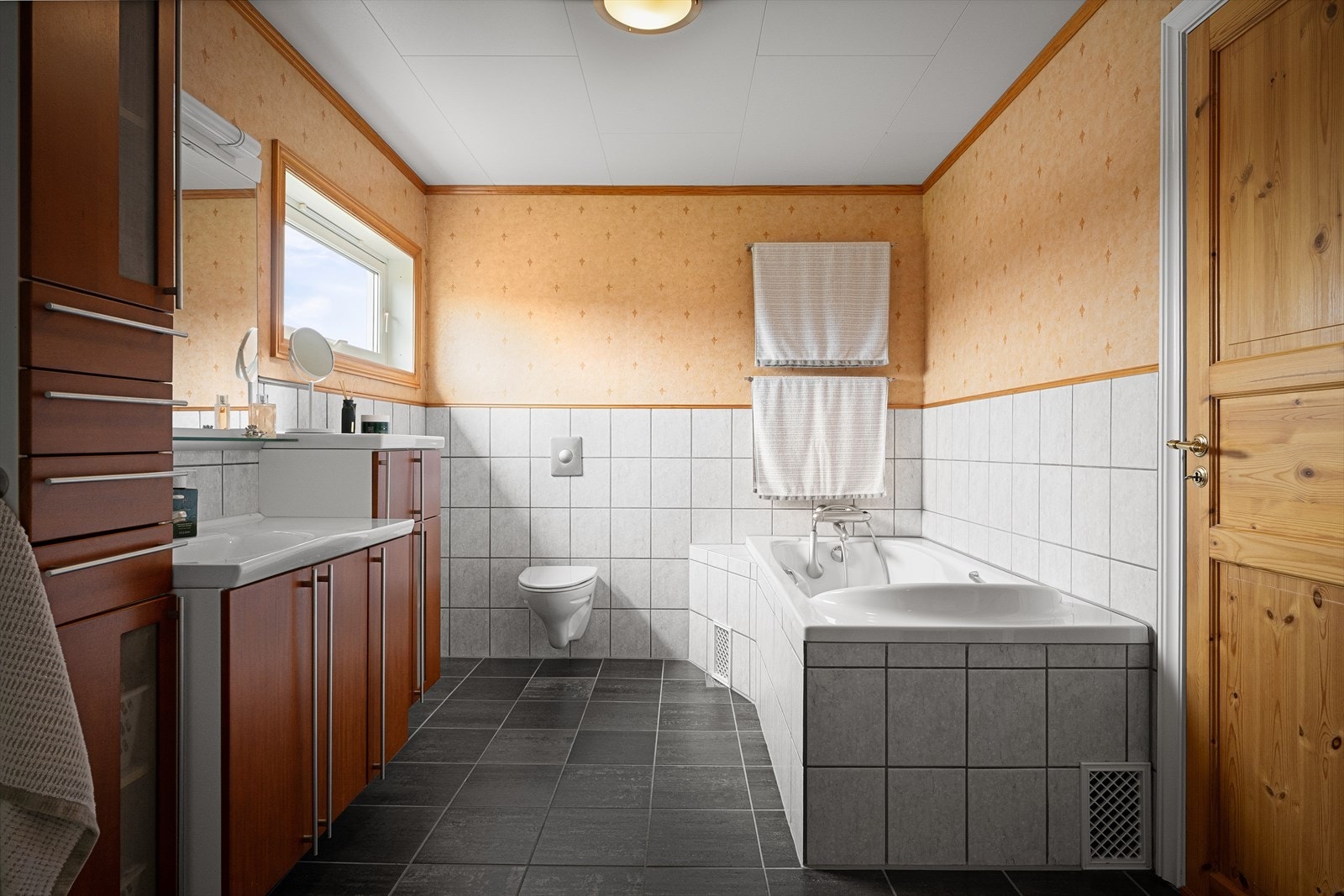 Badet har både innfliset badekar og dusjkabinett, samt vegghengt toalett. Galleribilde