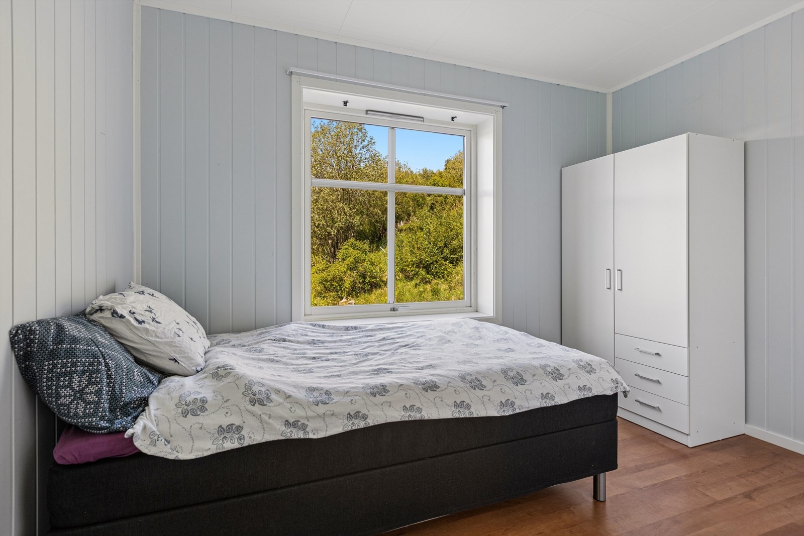 Soverom med plass til seng og garderobe, fine lysforhold fra vindu og rolig plassering vendt mot grønne omgivelser. Galleribilde
