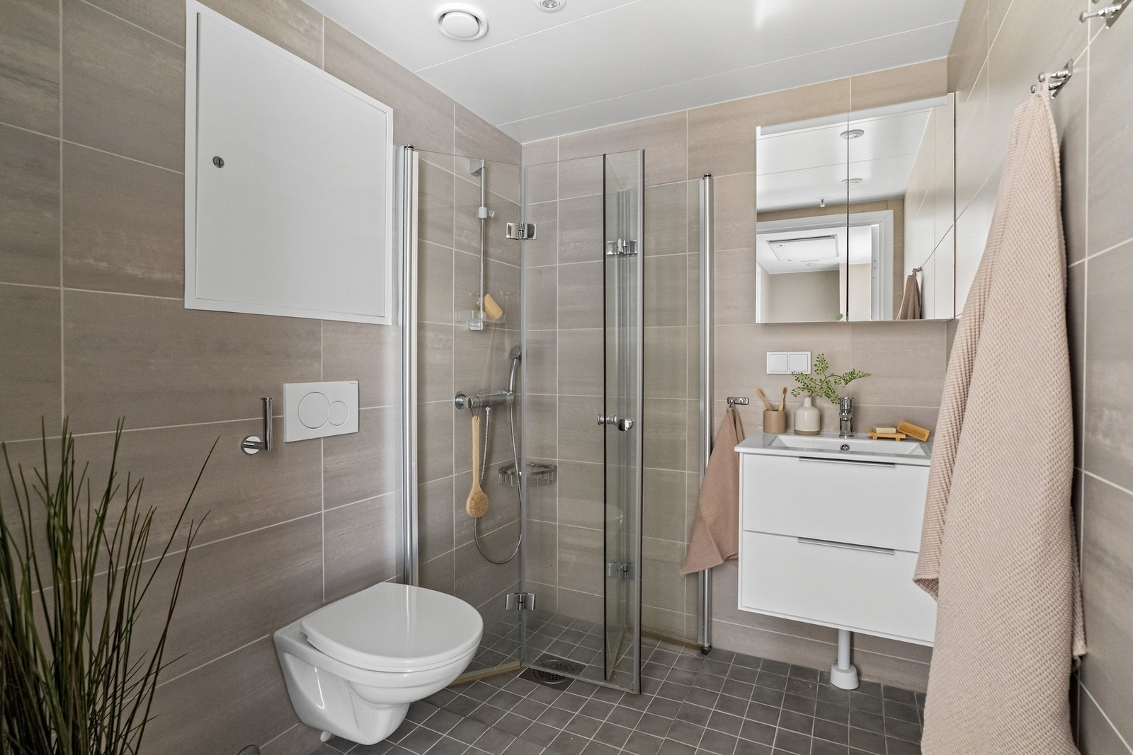 Pent og funksjonelt bad med flislagte overflater og moderne innredning. Badet er utstyrt med gulvvarme, servant med oppbevaringsplass, toalett og dusjløsning. Et komfortabelt og tidsriktig bad som dekker hverdagens behov på en god måte. Galleribilde