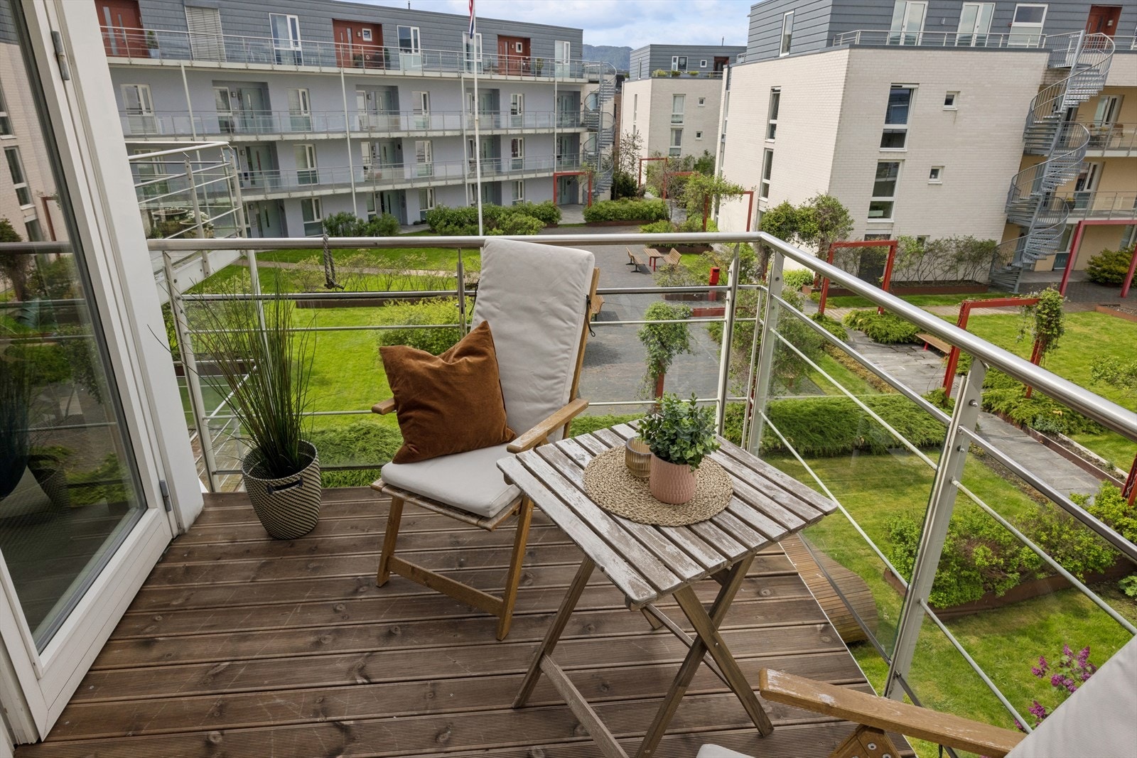 Fra balkongen har du utsyn over de pent opparbeidede fellesarealene. Galleribilde