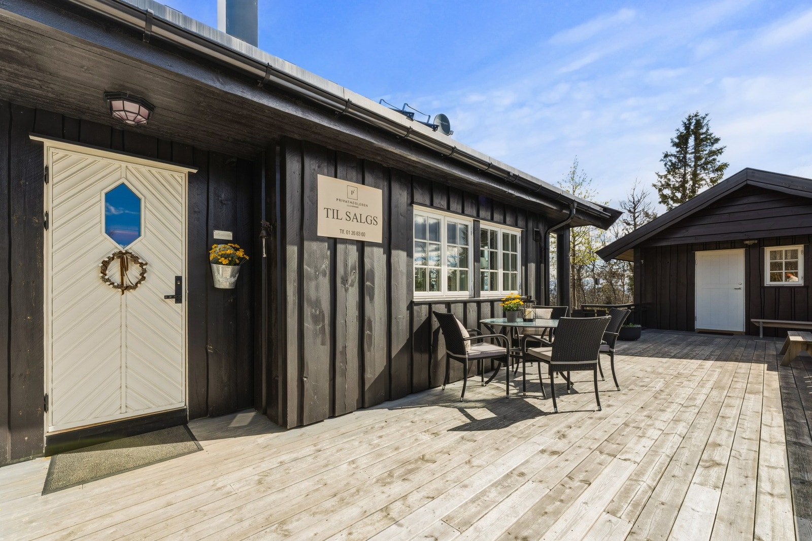 Koselig inngangsparti med stor platting utenfor, hvor morgenkaffen kan nytes. Galleribilde