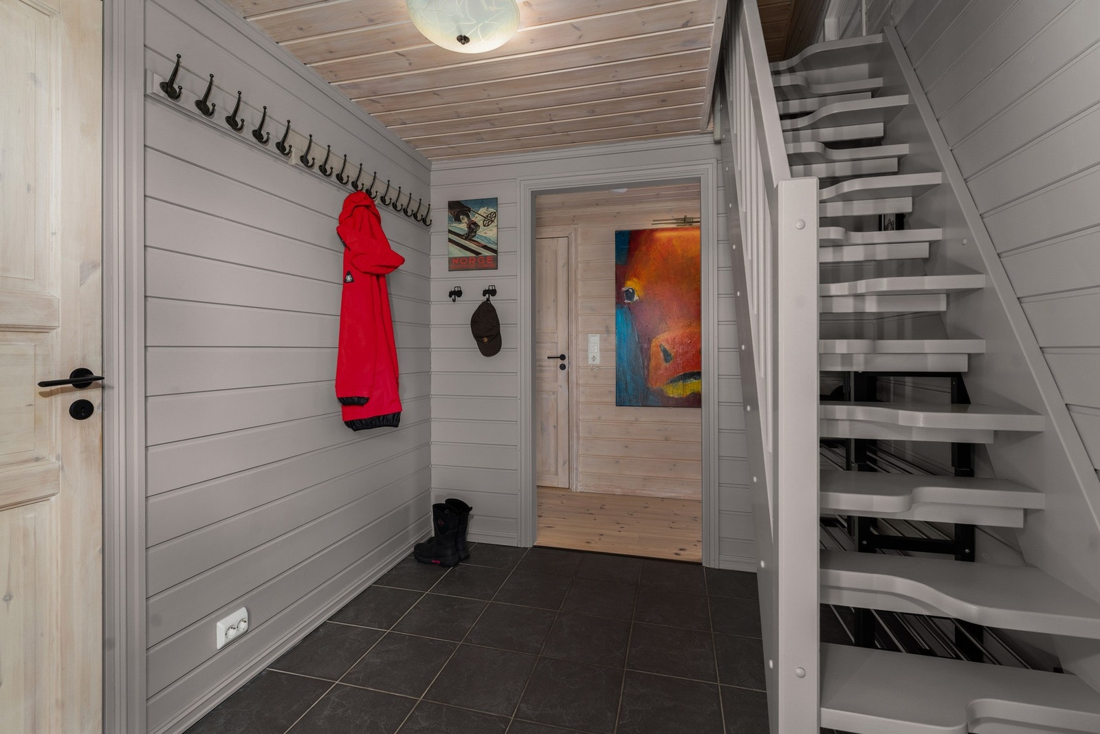 Fra entréen leder trappen opp til en romslig hems som utvider hyttas bruksmuligheter betydelig. Galleribilde