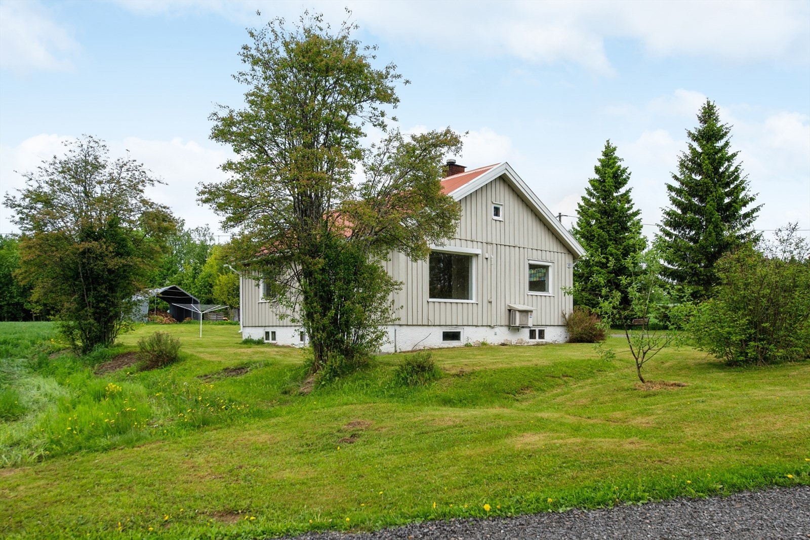 Eiendommen er opparbeidet med plen og gruset gårdsplass, og har et separat uthus med garasje. Galleribilde