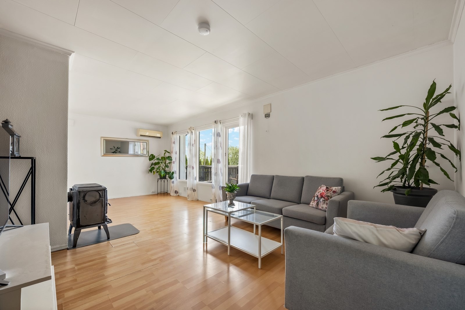 Stuen har en åpen løsning med god plass til sofagruppe. Rommet varmes effektivt opp av en vedovn og en varmepumpe. Galleribilde