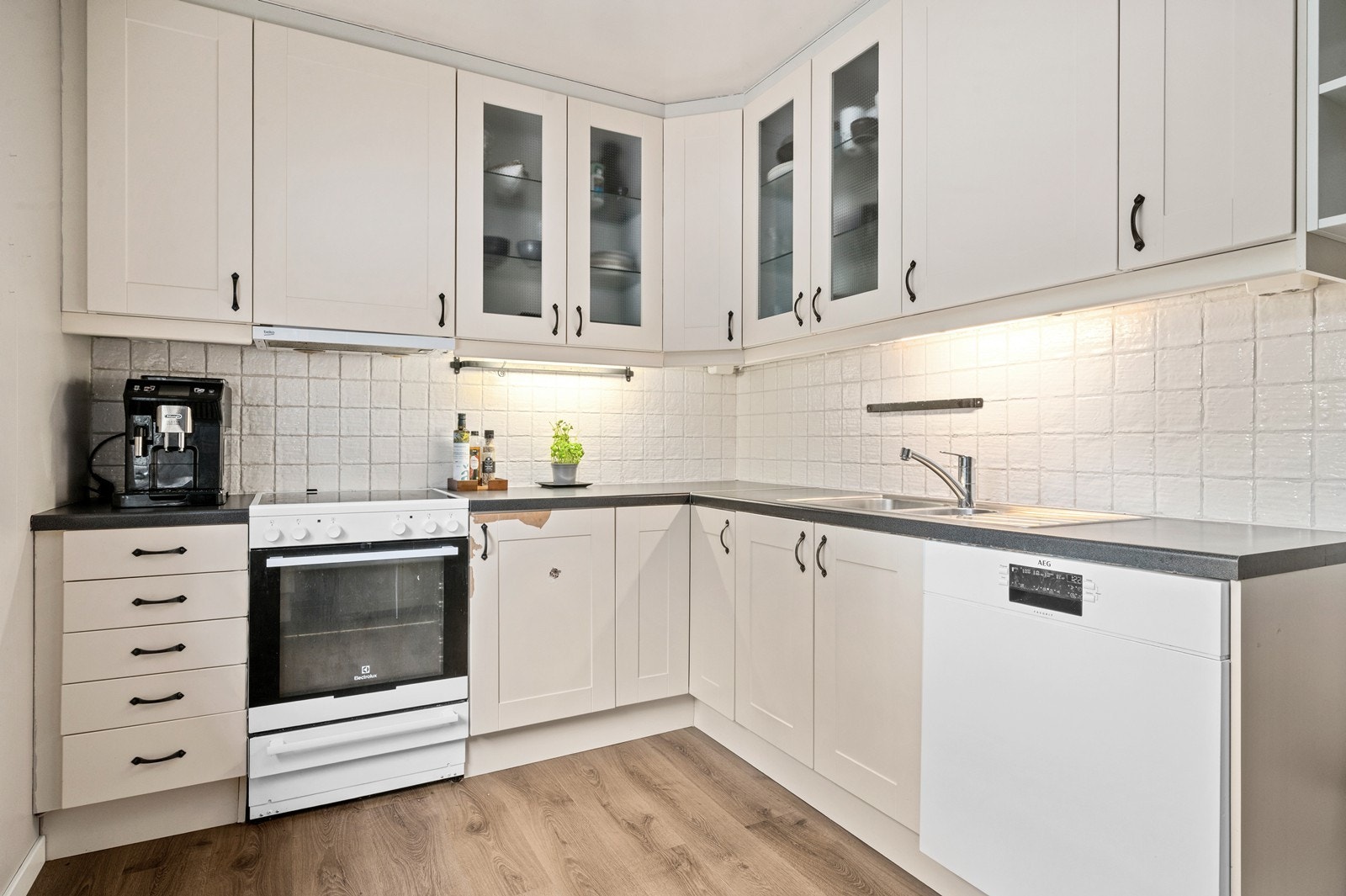 Kjøkkeninnredning fra 2004 med profilerte fronter og benkeplate i laminat. Uttrekkbar kjøkkenventilator med avtrekk ut sikrer god utlufting under matlaging. Innredningen har noen skader, og utbedringer må påregnes. Galleribilde