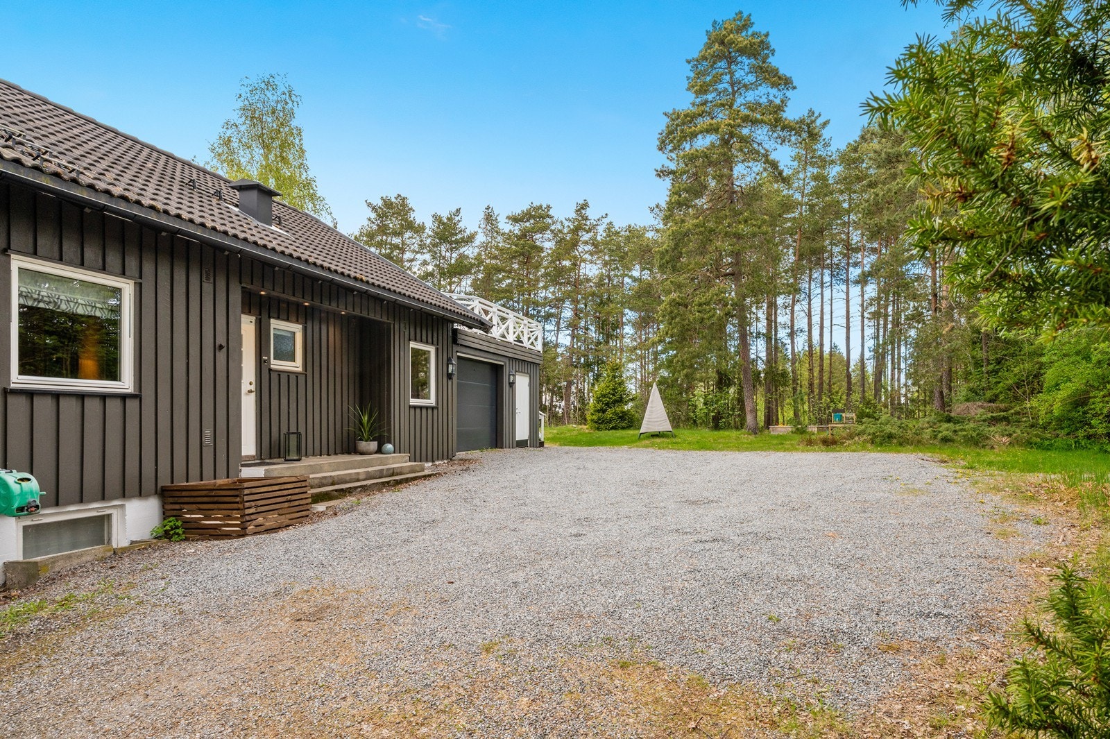 Gruset innkjørsel og gårdsplass med rikelig med biloppstillingsplasser i tillegg til parkering i garasjen. Galleribilde